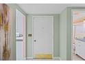 Light and bright entryway featuring neutral walls, an accent painting, and views into the kitchen and bathroom at 15635 Bertram Dr, Hudson, FL 34667