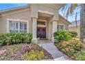 Inviting front entrance with decorative wreaths on the purple double doors and colorful landscaping at 1905 Firefern Ct, Trinity, FL 34655
