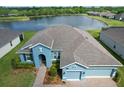 Overhead view of the home showcasing its location near a lake and the surrounding lush greenery at 19879 Tattnall Way, Brooksville, FL 34601