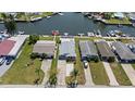 Aerial view of waterfront homes with docks and boat lifts on a sunny day in a canal community at 4400 Floramar Ter, New Port Richey, FL 34652