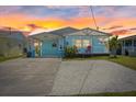 Charming coastal-style home with a front porch and a spacious driveway, featuring sunset at 4400 Floramar Ter, New Port Richey, FL 34652
