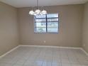 Dining room featuring tile flooring, a chandelier, and natural light streaming through the window at 4503 Sheffield Rd, Land O Lakes, FL 34639