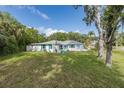 Well-maintained single-story home surrounded by mature trees, a manicured lawn, and light turquoise shutters at 4573 Ontario Dr, New Port Richey, FL 34652