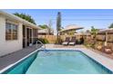 Inviting backyard pool with a sun deck, lounge chairs, umbrella, and well-maintained landscaping at 4731 Egret Rd, Venice, FL 34293