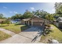 View of the house from the driveway showing well-maintained landscaping and a basketball hoop at 512 Winding Willow Dr, Palm Harbor, FL 34683