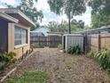 Spacious backyard with a wooden fence and storage shed, offering privacy and functionality at 5406 Dartmouth Rd, New Port Richey, FL 34652