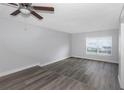 Bright bedroom featuring wood-look flooring, a ceiling fan, and a large window at 5651 Townhouse Dr # 5651, New Port Richey, FL 34652