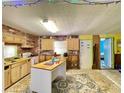 Kitchen with wooden cabinets, brick wall, kitchen island and a view to an adjacent room at 6045 Colony Cir, Weeki Wachee, FL 34607