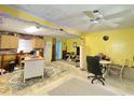 Spacious living room featuring bright yellow walls, colorful lights and carpet squares at 6045 Colony Cir, Weeki Wachee, FL 34607