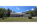 Single-story home boasts a brick facade, attached garage, and a well-manicured lawn with mature trees at 6516 Hillview Rd, Spring Hill, FL 34606