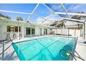 Sparkling pool with an enclosed screen, surrounded by a patio with barstools, perfect for outdoor relaxation at 6552 River Rd, New Port Richey, FL 34652
