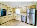 Bright kitchen with stainless steel appliances, wooden cabinets, and tile floors at 6710 Hickorywood Ln # 1B, New Port Richey, FL 34653