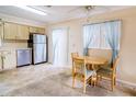 Cozy eat-in kitchen featuring stainless steel refrigerator, wood table, and natural light at 6710 Hickorywood Ln # 1B, New Port Richey, FL 34653