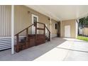 Exterior view of the carport featuring wooden stairs and a storage area at 846 Oakwood Dr, Tarpon Springs, FL 34689