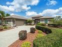 Close up showcasing the home's front exterior with well-maintained landscaping and a lengthy paver driveway at 9032 Cypress Glen Ct, Weeki Wachee, FL 34613