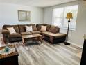Inviting living room with comfortable seating, wood-look floors, and a stylish coffee table at 9136 Mark Twain Ln, Port Richey, FL 34668