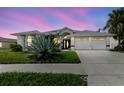Beautiful home featuring a two-car garage, well-manicured lawn, and gorgeous front yard landscaping at 9301 Tournament Dr, Hudson, FL 34667