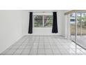 Empty room with sliding glass door, tile floors, and a view to the backyard at 9316 Whitman Ln, Port Richey, FL 34668