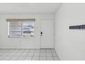 Light and airy entryway featuring tile floors, front door, and ample natural light from window at 9316 Whitman Ln, Port Richey, FL 34668