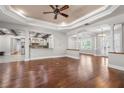 Spacious living room with hardwood floors, tray ceiling, and archways to other rooms in the home at 10110 Weeks Dr, Brooksville, FL 34601