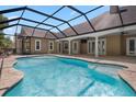 A refreshing screened-in pool features brick-style tiling and provides an idyllic outdoor experience at 10110 Weeks Dr, Brooksville, FL 34601