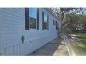 Side view of a single-story house with white siding and black shutters, showcasing its simple elegance at 11304 Altoona Ave, New Port Richey, FL 34654