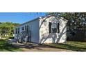 Inviting white home features black shutters, and a stairway leading to the front door at 11304 Altoona Ave, New Port Richey, FL 34654