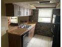 This kitchen has a stainless steel sink, wooden cabinets, and a black refrigerator at 11515 Meredith Ln, Port Richey, FL 34668