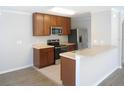 Modern kitchen with stainless steel appliances, brown cabinets, and an eat-in breakfast bar at 12431 White Bluff Rd, Hudson, FL 34669