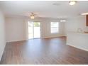 Bright and airy living room featuring hardwood floors, ceiling fan and sliding glass doors to the backyard at 12431 White Bluff Rd, Hudson, FL 34669