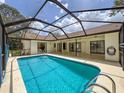 A screened-in pool features clear blue water, a ladder, and ample deck space for entertaining at 1280 Thornton Ct, Spring Hill, FL 34608