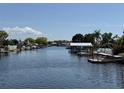 Scenic waterfront view featuring the canal and neighborhood boat docks under a partly cloudy blue sky at 1412 Linstock Dr, Holiday, FL 34690