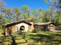 A cozy single-Gathering home featuring a rustic stone facade and lush greenery, creating a private feel at 18255 Lake Lindsey Rd, Brooksville, FL 34601