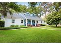 Inviting home featuring a spacious front lawn, vibrant landscaping, and a welcoming facade at 417 Inness Dr, Tarpon Springs, FL 34689