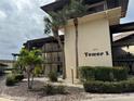 Tower 1 exterior view of the condominium complex surrounded by landscaped gardens and mature palm trees at 4678 Marine Pkwy # 305, New Port Richey, FL 34652