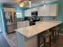 Bright kitchen with white cabinets, stainless steel appliances, mosaic tile backsplash, and quartz countertops at 4678 Marine Pkwy # 305, New Port Richey, FL 34652