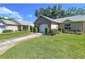 Beautifully landscaped home with lush green grass and trimmed bushes leading to the attached one car garage at 4836 Alamo Ct, New Port Richey, FL 34655