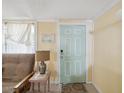 Inviting entryway with a futon, side table, and a decorative front door in the background at 6329 Alaska Ave, New Port Richey, FL 34653