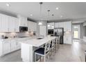 Bright kitchen with white cabinets, a large center island, and stainless-steel appliances at 6770 Pebblebrooke Way, Zephyrhills, FL 33541