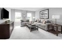 Cozy living room with gray couches, patterned pillows, and a television at 6770 Pebblebrooke Way, Zephyrhills, FL 33541