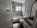 Modern bathroom with a tub and shower, new vanity, sleek fixtures, and stylish tile at 825 Lincoln Ave, Tarpon Springs, FL 34689