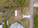 Aerial view of a single-story home featuring a pristine driveway, brown roof, and a private backyard at 8466 Eldridge Rd, Spring Hill, FL 34608