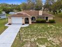 Inviting single-story home featuring a lush front lawn, stone details, and a convenient two-car garage at 8466 Eldridge Rd, Spring Hill, FL 34608