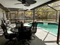 Screened-in pool area with a spa and outdoor seating, surrounded by lush greenery at 8930 Phelps Rd, Hudson, FL 34667