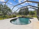 Enjoy the outdoors in this screened-in pool area, complete with waterfall feature and lush landscaping at 10318 Piper Dr, New Port Richey, FL 34654