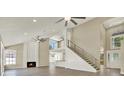 Inviting living room with a modern staircase, fireplace, and an open-concept design to the kitchen at 10423 Ashley Oaks Dr, Riverview, FL 33578