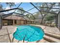 Inviting in-ground pool inside screened enclosure, surrounded by brick patio with outdoor furniture at 10531 Lakeview Dr, New Port Richey, FL 34654