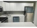 Modern kitchen with stainless steel appliances, white cabinets, and bright countertops at 12119 Sunny Glen Ln # G2, Hudson, FL 34669