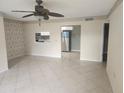 Cozy living room featuring tile floors, ceiling fan, and a kitchen view at 12119 Sunny Glen Ln # G2, Hudson, FL 34669