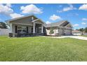 Lovely single story home with covered porch, black shutters and 3-car garage at 12848 Hilary St, Spring Hill, FL 34609